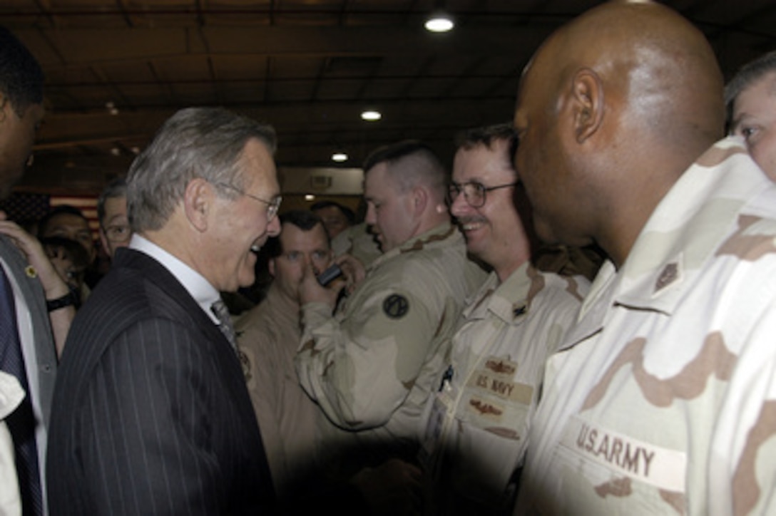 Secretary of Defense Donald H. Rumsfeld shakes hands with some of the troops after a town hall meeting at Central Command Forward headquarters in Qatar, on April 28, 2003. Rumsfeld, accompanied by Army Gen. Tommy Franks, commander of U.S. Central Command, is visiting the troops and senior leadership in the Persian Gulf region. 