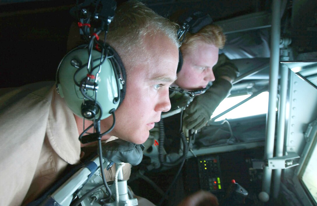 OPERATION IRAQI FREEDOM -- First Lt. Eric Adcock (right), a KC-135 Stratotanker co-pilot, watches as Airman 1st Class Kenny Harwood, boom operator, refuels an E-8C Joint Stars aircraft.  Adcock's older brother, 1st Lt. Nick Adcock, was the pilot of the E-8C being refueled.  (U.S. Air Force photo by Master Sgt. Mark Bucher)