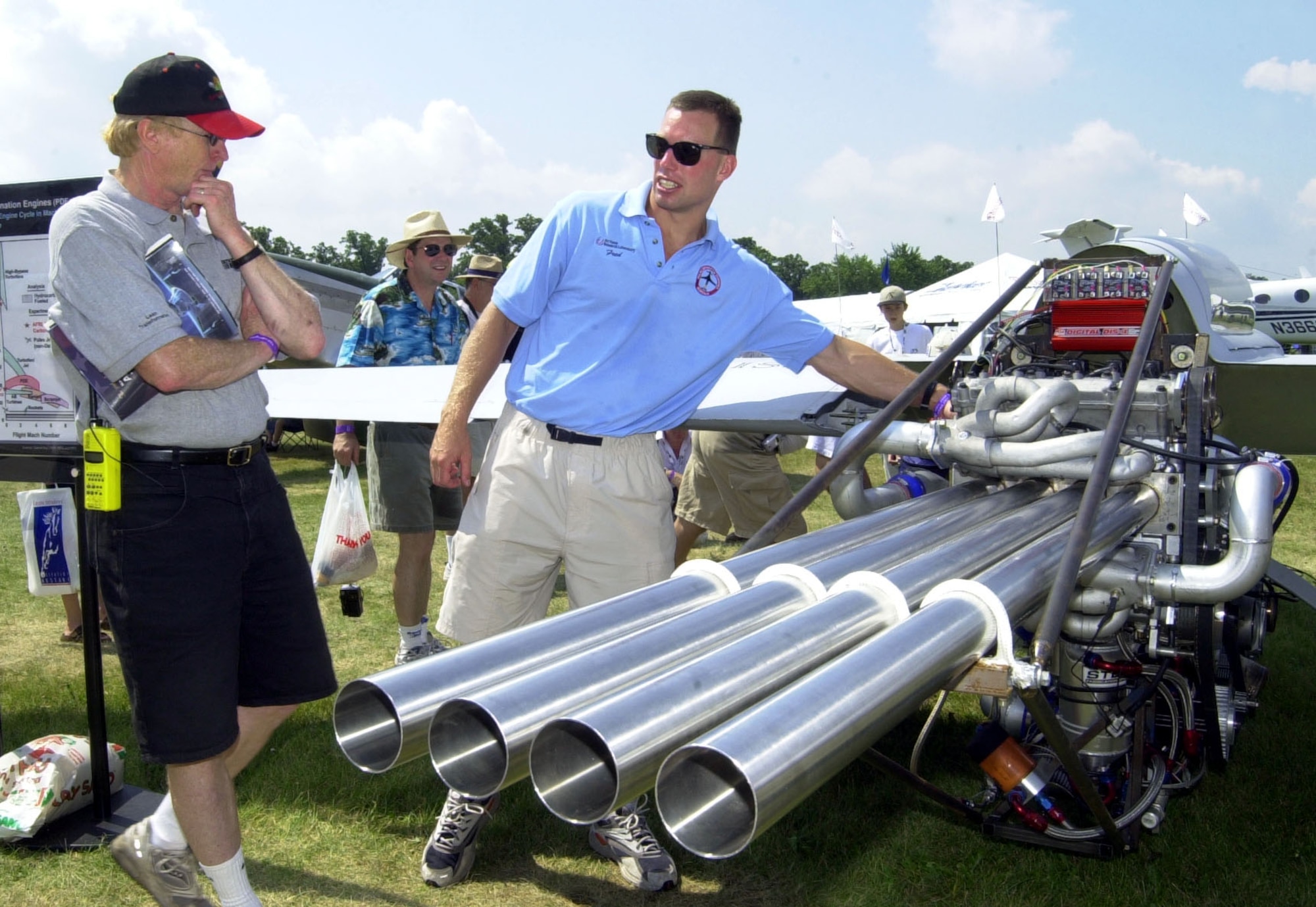 OSHKOSH, Wis. -- Dr. Fred Shauer talks to Experimental Aircraft Association's AirVenture visitors about the pulsed detonation engine the Air Force Research Laboratory from Wright-Patterson Air Force Base, Ohio, has on display.  The engine is a test bed for future engines that will be capable of powering aircraft to speeds of up to Mach 4.  (U.S. Air Force Photo by Bill McCuddy)