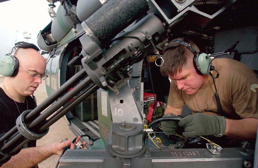 LUNGI, Sierra Leone -- Tech. Sgt. Todd Bailey (left) and Staff Sgt. Matthew Kelly work on a GAU-2 minigun mounted on an HH-60G Pave Hawk helicopter here.  They are deployed from the 85th Maintenance Squadron at Naval Air Station Keflavik, Iceland.  (U.S. Air Force photo by Tech. Sgt. Justin D. Pyle)