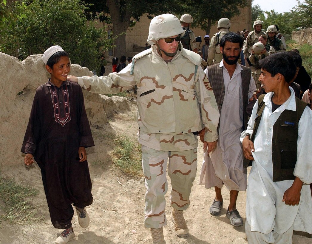 JAMADAAR, Afghanistan -- Children here walk with Master Sgt. Russ Hastings from the 455th Expeditionary Operations Group on Aug. 3. People from the group visited the village to show peace by offering gifts and supplies.  (U.S. Air Force photo by Staff Sgt. Russell Wicke)