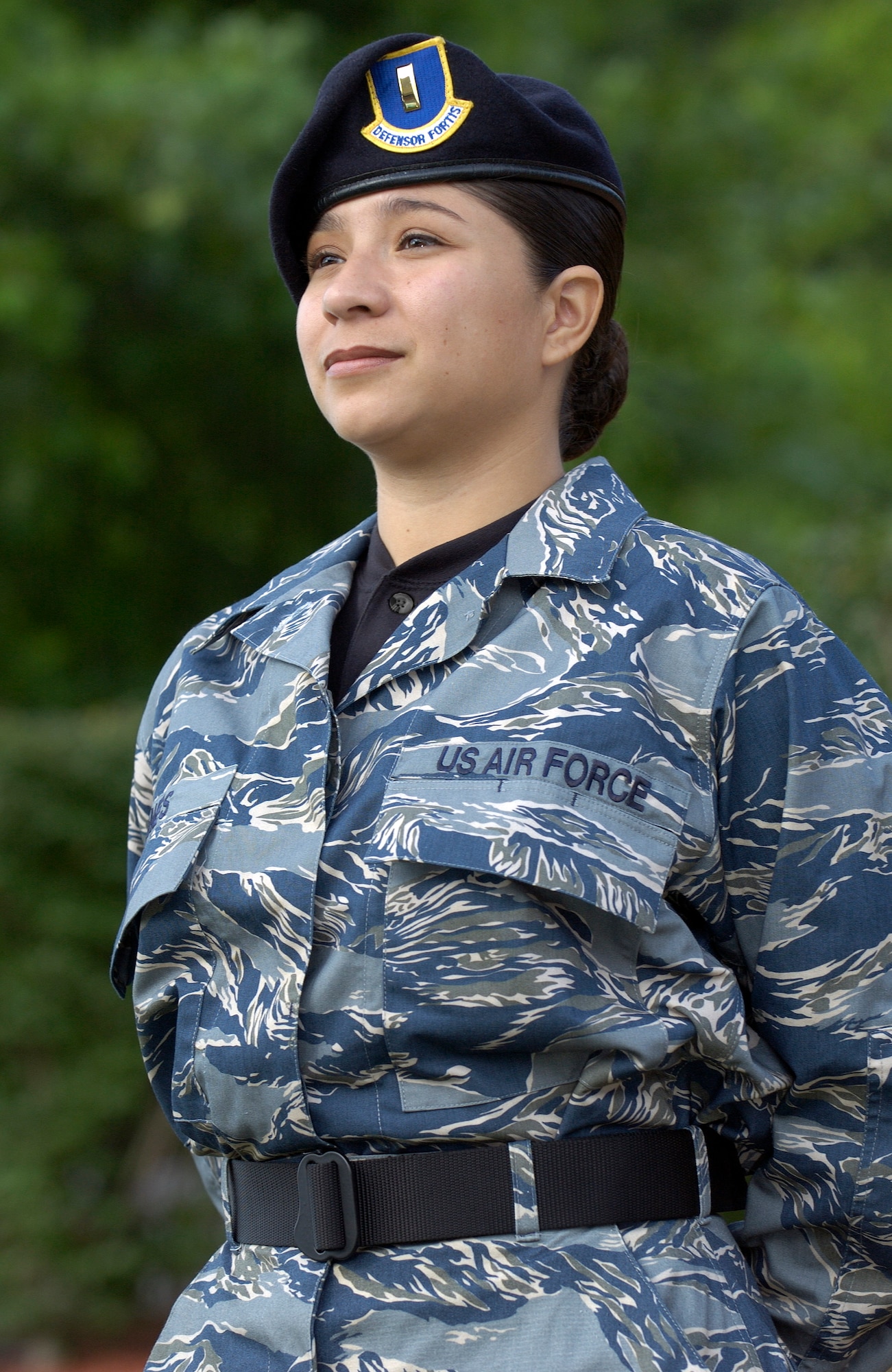 ANDREWS AIR FORCE BASE, Md. (AFPN) -- Second Lt. Arcelia Miller, from the Air Force’s special security office, puts the Air Force test utility uniform through its paces at an entry control point here.  The blue, gray and green tiger-stripe camouflage ensemble includes many new features intended to increase functionality while providing a distinctive look for the 21st century airmen.  The uniforms will undergo wear-testing beginning in January 4.  Airmen from a cross section of Air Force career fields will provide feedback on the fit, durability and functionality of the proposed ensemble which will come in men's and women's cuts.  (U.S. Air Force photo by Master Sgt. Jim Varhegyi) 
