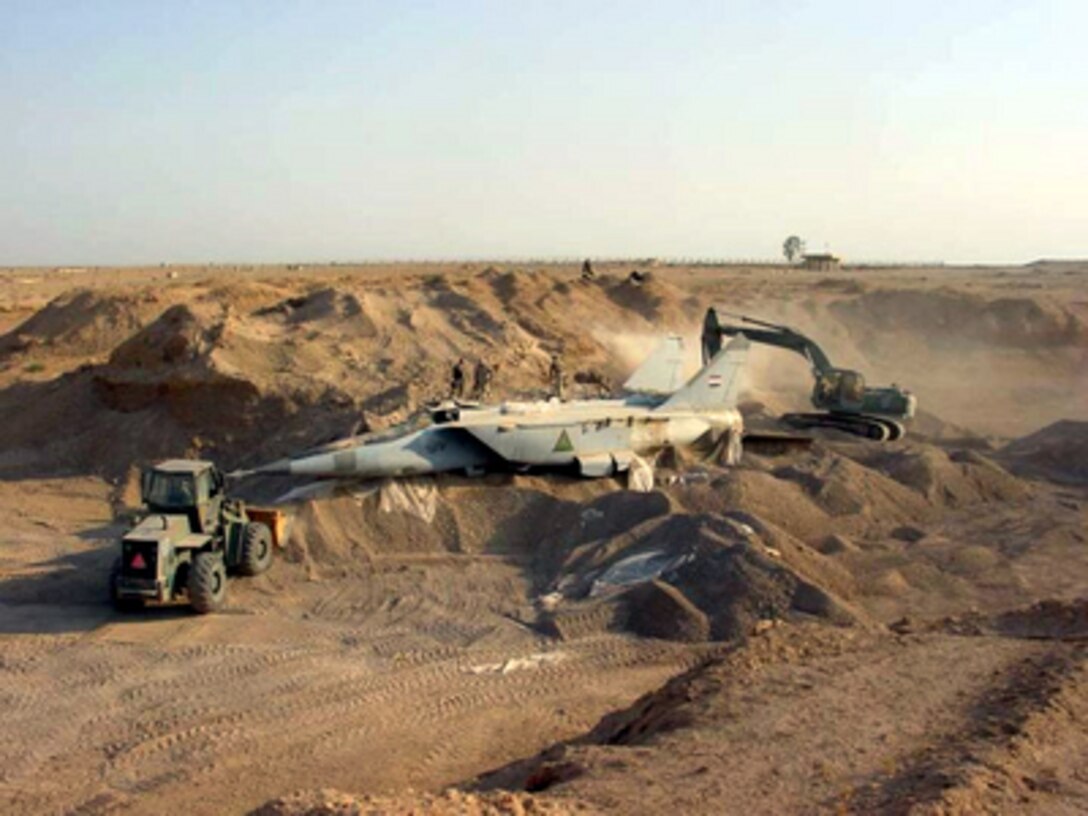 A U.S. military search team uncovers a MiG-25R Foxbat-B from beneath the sands in Iraq on July 6, 2003. Several MiG-25s and Su-25 aircraft have been found buried at Al-Taqqadum airfield west of Baghdad. 