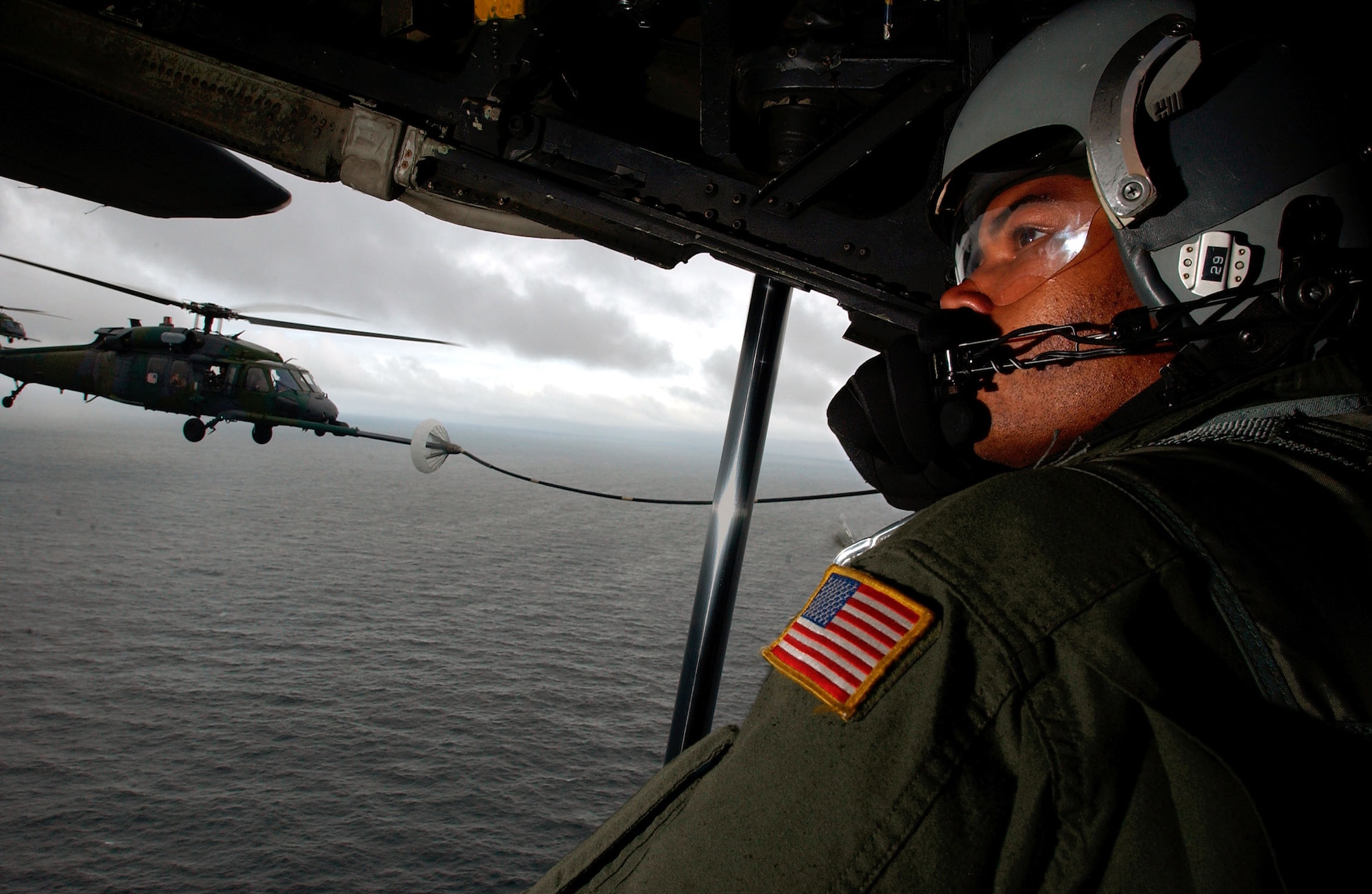 OVER THE ATLANTIC OCEAN -- Staff Sgt. Deshield Godet, a loadmaster on an MC-130P Combat Shadow, talks with pilots while an HH-60G Pave Hawk refuels after completing a mission into the U.S. Embassy in Liberia Aug. 6.  (U.S. Air Force photo by Tech. Sgt. Justin D. Pyle)