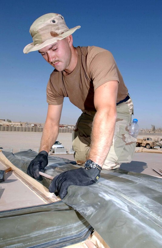 TALLIL AIR BASE, Iraq (AFPN) -- Senior Airman Jason Roush works on the roof of a small base exchange here.  He is assigned to the 332nd Expeditionary Civil Engineer Squadron.  (U.S. Air Force photo by Senior Airman Karolina Gmyrek)