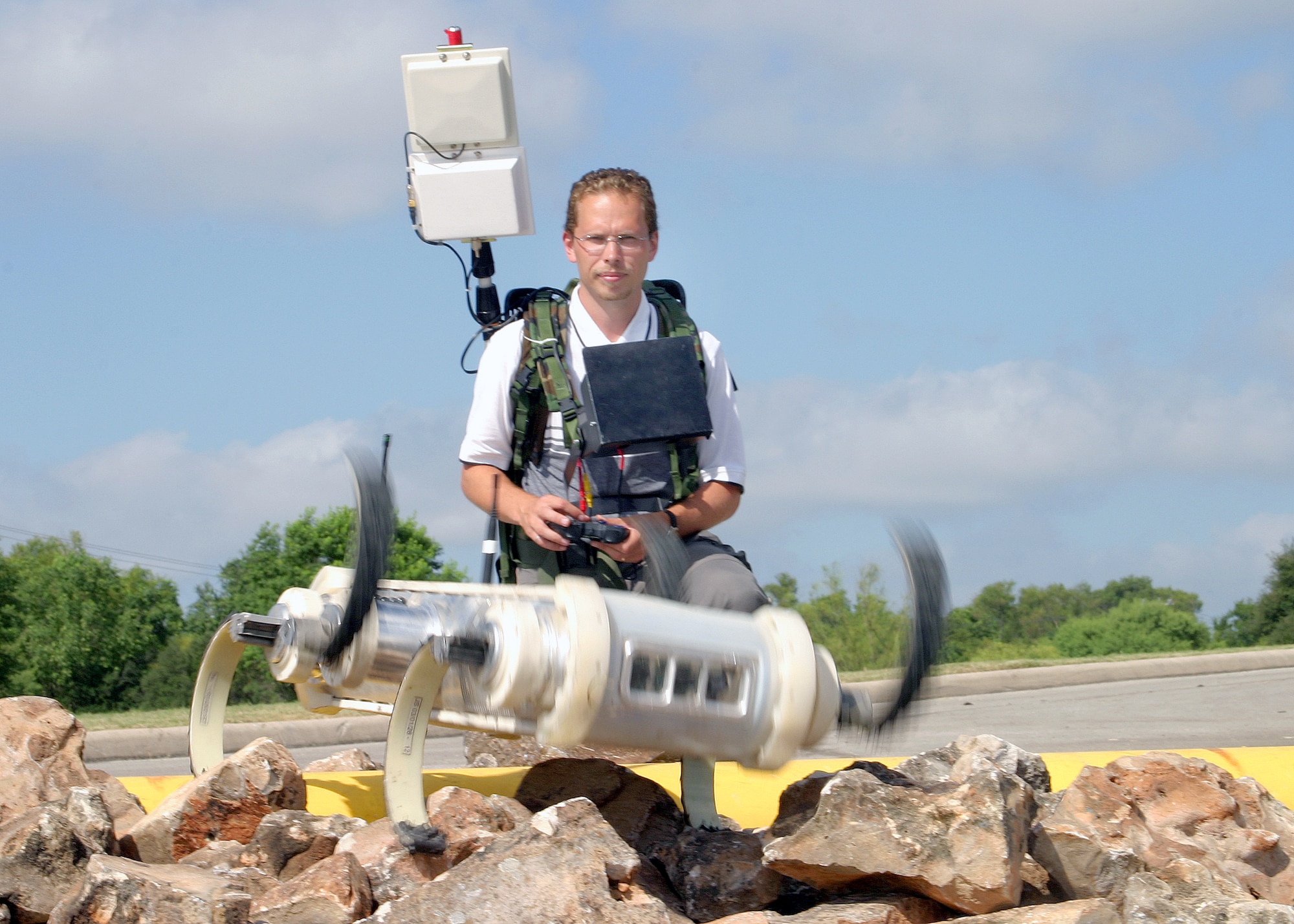 SAN ANTONIO -- Chris Prahacs walks Robotic Hexapod, a biologically inspired robot with six rotating legs, over a pile of rocks during the Lackland Force Protection Battlelab Exposition on Aug. 6 at Southwest Research Institute here.  The 30-pound roach-like robot also swims.  (U.S. Air Force photo by Robbin Cresswell)