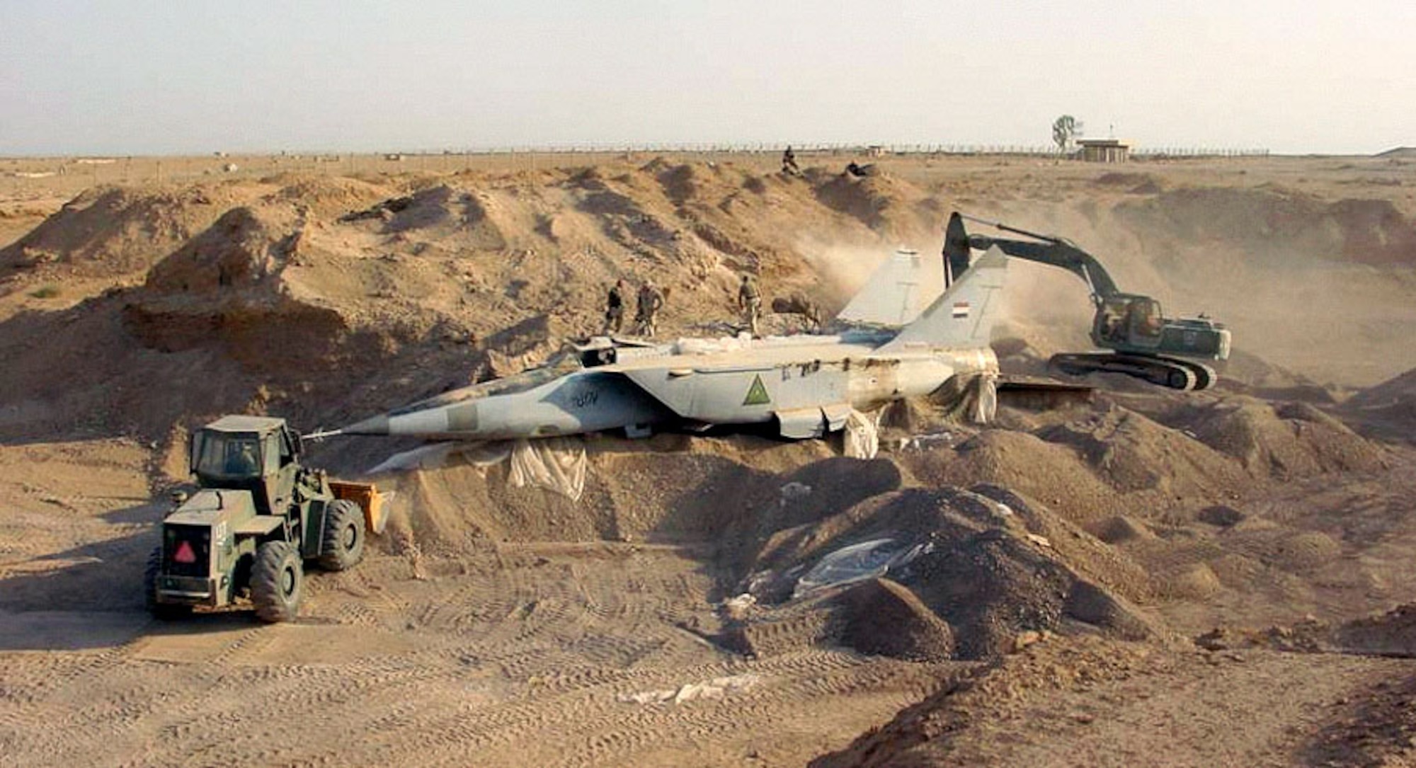 OPERATION IRAQI FREEDOM -- A search team discovers a MiG-25 Foxbat buried beneath the sands in Iraq. Several MiG-25 interceptors and Su-25 ground attack jets have been found buried at Al-Taqqadum air field west of Baghdad. (U.S. Air Force photo by Master Sgt. T. Collins)