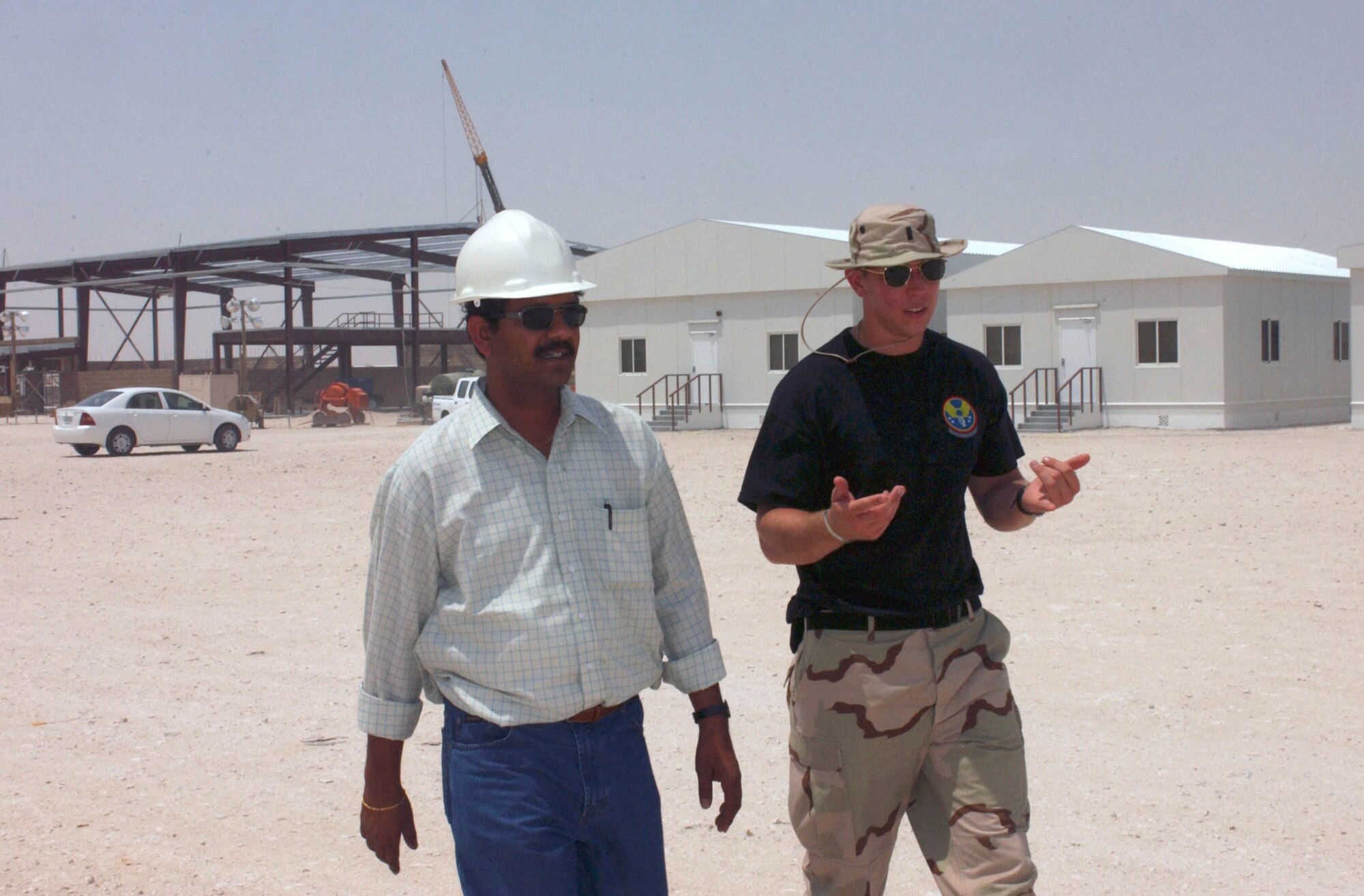 AL UDEID AIR BASE, Qatar -- First Lt. Steven Thomas (right) works closely with local contractors including N. Rajiv Shanker.  Expeditionary Village is being built to house at least 5,500 airmen at two per room.  Besides living quarters, construction projects include a new gymnasium, theater, chapel and base exchange with other amenities.  (U.S. Air Force photo by Master Sgt. John E. Lasky)