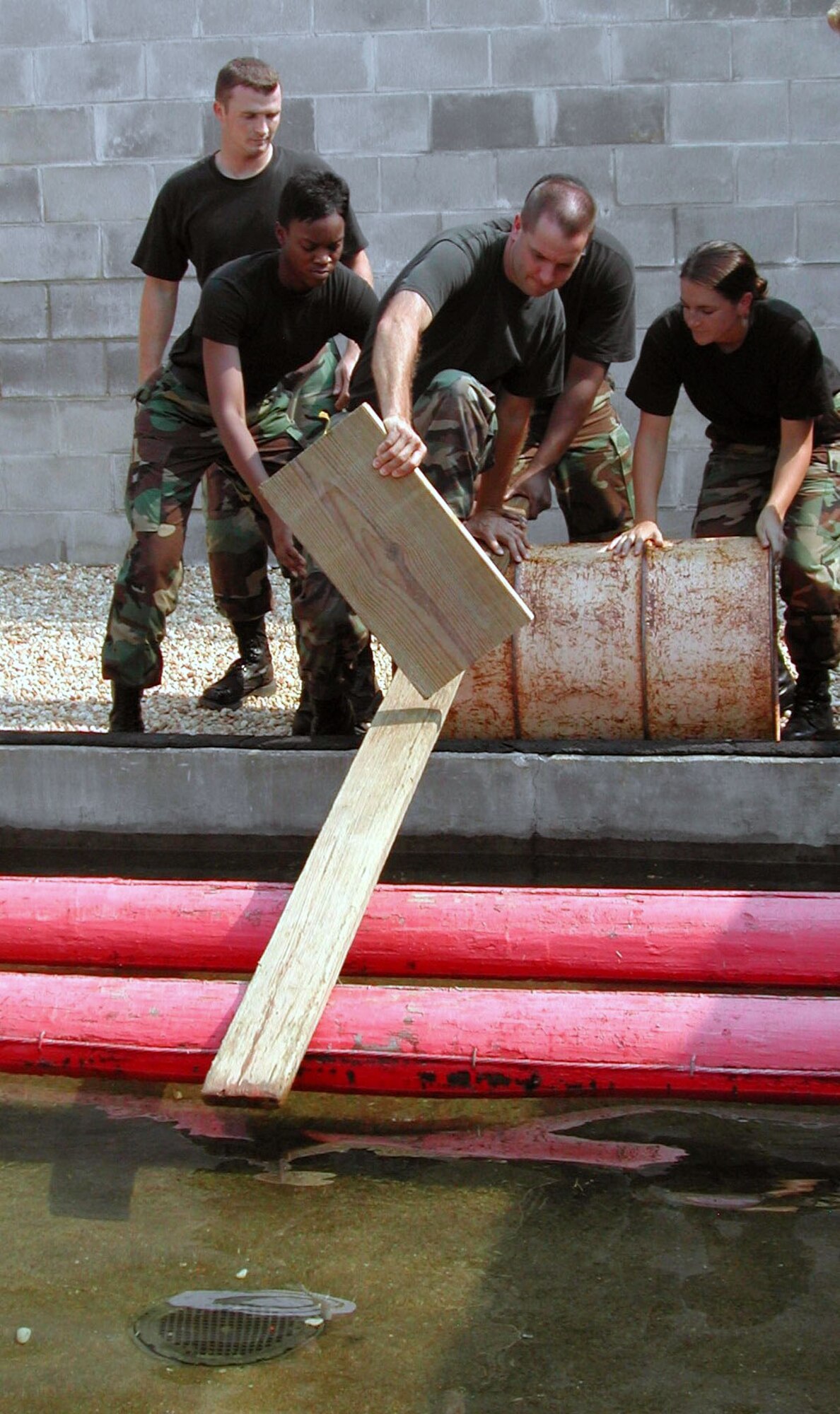 MAXWELL AIR FORCE BASE, Ala. -- From left, 2nd Lts. Alan Condor and Kira Harvey, Master Sgt. Jerry Gibson and 2nd Lt. Patricia Currin attempt to cross one of the water obstacles in a "Project X" exercise during Combined Operations Week.  (U.S Air Force photo by Carl Bergquist)