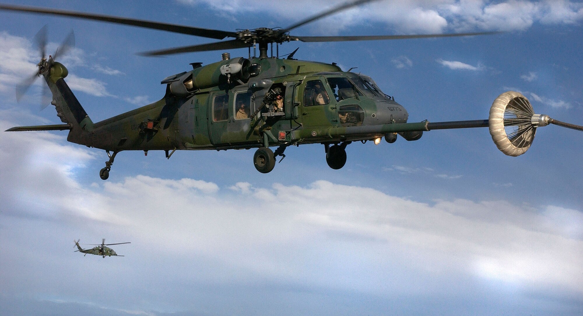 NAVAL AIR STATION FALLON, Nev. -- A pair of HH-60G Pave Hawks from the 41st Rescue Squadron, Moody Air Force Base, Ga., conduct in-flight refueling here as part of Desert Rescue XI on August 13, 2003. The joint-service combat search and rescue training exercise simulates downed aircrew behind enemy lines and allows airmen to practice rescue-related missions.  (U.S. Air Force photo by U.S. Air Force Staff Sgt. Aaron D. Allmon II)