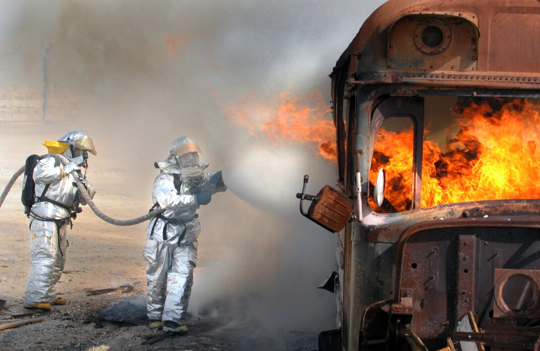 OPERATION ENDURING FREEDOM -- Staff Sgts. Don Doose (right) and Jerry Bowling douse a training fire at a forward-deployed location in Southwest Asia.  They are firefighters deployed to the 380th Expeditionary Civil Engineer Squadron.  Doose is from the 934th Civil Engineer Squadron at Minneapolis-St. Paul International Airport Air Reserve Station, Minn., and Bowling is from the 94th Civil Engineer Squadron at Dobbins Air Reserve Base, Ga.  (U.S. Air Force photo by Maj. Robert Couse-Baker)