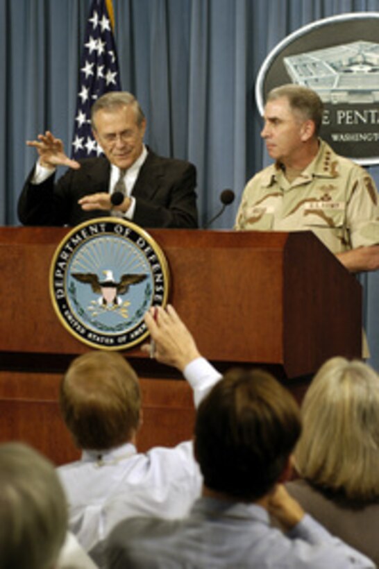 Secretary of Defense Donald H. Rumsfeld and Army Gen. John P. Abizaid, commander, U.S. Central Command, provide reporters with an operational update on the current situation in Iraq during a Pentagon press briefing on Aug. 21, 2003. Abizaid is in Washington to meet with Rumsfeld and other senior DoD leaders. 