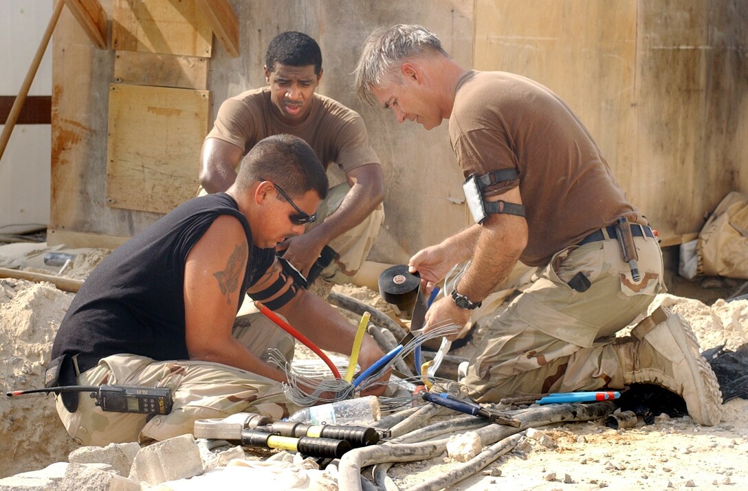 OPERATION ENDURING FREEDOM -- (Left to right) Airmen 1st Class Trevor Jones and Mike Nettles, and Tech. Sgt. Terry Zarazee splice electrical cables at a forward-deployed location in Southwest Asia.  The work is part of an upgrade of the electrical system at the base.  The airmen are assigned to the 380th Civil Engineer Squadron.  Zarazee and Jones are deployed from Dyess Air Force Base, Texas.  Nettles is deployed from Beale AFB, Calif.  (U.S. Air Force photo by Staff Sgt. Kyle Smith)