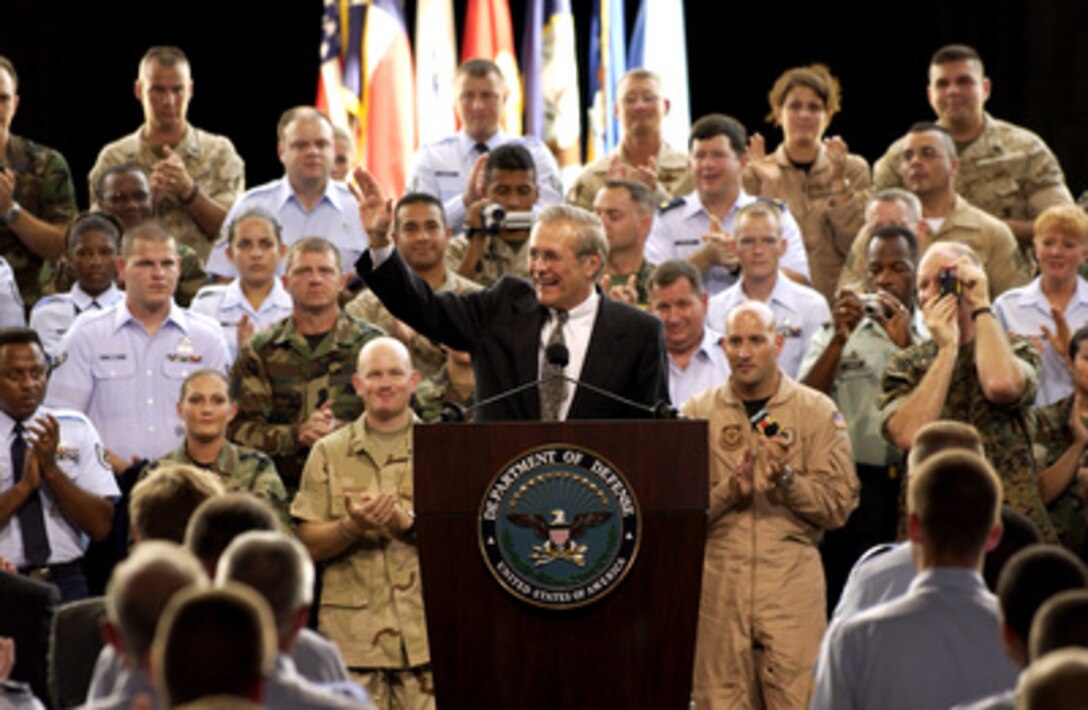 Secretary of Defense Donald H. Rumsfeld waves to members of the audience after being introduced during a town hall meeting at Lackland Air Force Base, San Antonio, Texas, on Aug. 25, 2003. Rumsfeld delivered his opening remarks then fielded questions from military and civilian attendees. The forum allowed people from San Antonio area bases to direct their questions to the top man at the Defense Department. 