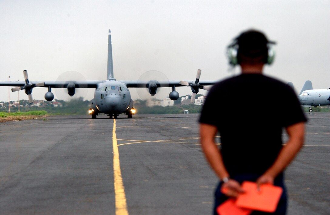 DAKAR, Senegal -- Senior Airman Brandon Hashida waits to guide in a C-130 Hercules as it taxis after landing here.  Hashida is deployed from Ramstein Air Base, Germany to the 398th Air Expeditionary Group.  (U.S. Air Force photo by Tech. Sgt. Justin D. Pyle)
