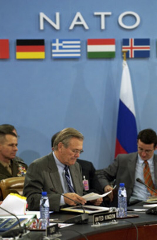 Secretary of Defense Donald H. Rumsfeld looks over some papers as he prepares for a meeting of NATO defense ministers in Brussels, Belgium, on Dec. 1, 2003. Rumsfeld is at NATO headquarters for a two-day meeting of allied defense ministers to discuss expanding NATO's mission. 