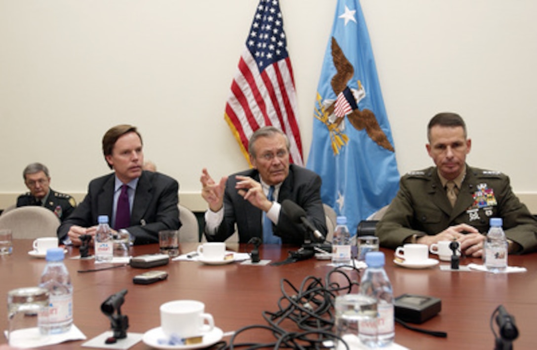 Secretary of Defense Donald H. Rumsfeld (center) responds to a reporter's question during a press conference at NATO headquarters in Brussels, Belgium, on Dec. 2, 2003. U.S. Ambassador to NATO R. Nicholas Burns (left) and Vice Chairman of the Joint Chiefs of Staff Gen. Peter Pace (right), U.S. Marine Corps, joined Rumsfeld as he updated the press on the progress of the meetings. Rumsfeld is at NATO headquarters for a two-day meeting of allied defense ministers to discuss expanding NATO's mission. 