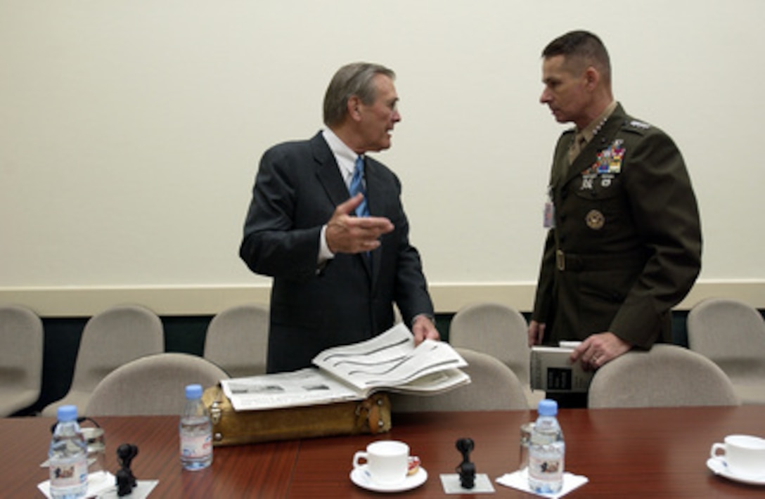 Secretary of Defense Donald H. Rumsfeld speaks with Vice Chairman of the Joint Chiefs of Staff Gen. Peter Pace, U.S. Marine Corps, prior to a NATO conference in Brussels, Belgium, on Dec. 2, 2003. Rumsfeld is at NATO headquarters for a two-day meeting of allied defense ministers to discuss expanding NATO's mission. 
