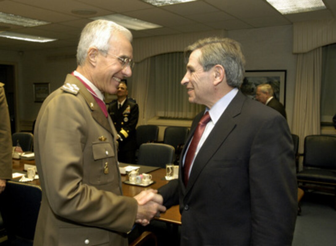 Deputy Secretary of Defense Paul Wolfowitz (right) welcomes Chief of the Italian Defense Staff Gen. Rolando Mosca Moschini to his Pentagon conference room for a meeting on Dec. 4, 2003. Wolfowitz and Moschini, along with a small number of their senior advisors, are meeting to discuss a range of security issues of mutual interest. Italy has been a strong member of the coalition in the reconstruction of Iraq, sending 2,500 troops to help maintain law and order. 