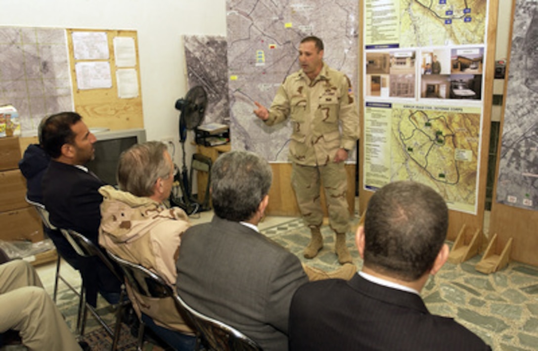 Army Lt. Col. Caraccilo briefs Secretary of Defense Donald H. Rumsfeld on the Iraqi Civil Defense Corps training in Baghdad, Iraq, on Dec. 6, 2003. Rumsfeld is in Iraq to meet with members of the Coalition Provisional Authority, senior military leaders and the troops deployed there. 