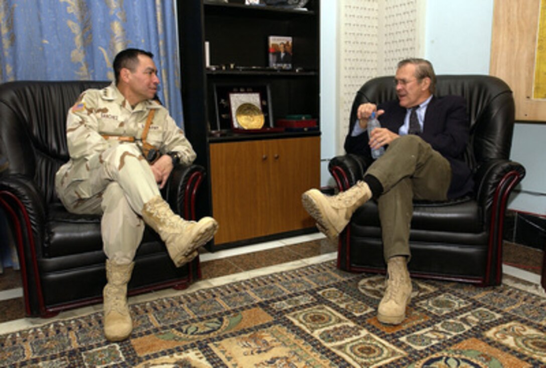 Secretary of Defense Donald H. Rumsfeld speaks with Army Lt. Gen. Ricardo Sanchez at the Coalition Provisional Authority headquarters in Baghdad, Iraq, on Dec. 6, 2003. Rumsfeld is in Iraq to meet with members of the Coalition Provisional Authority, senior military leaders and the troops deployed there. 