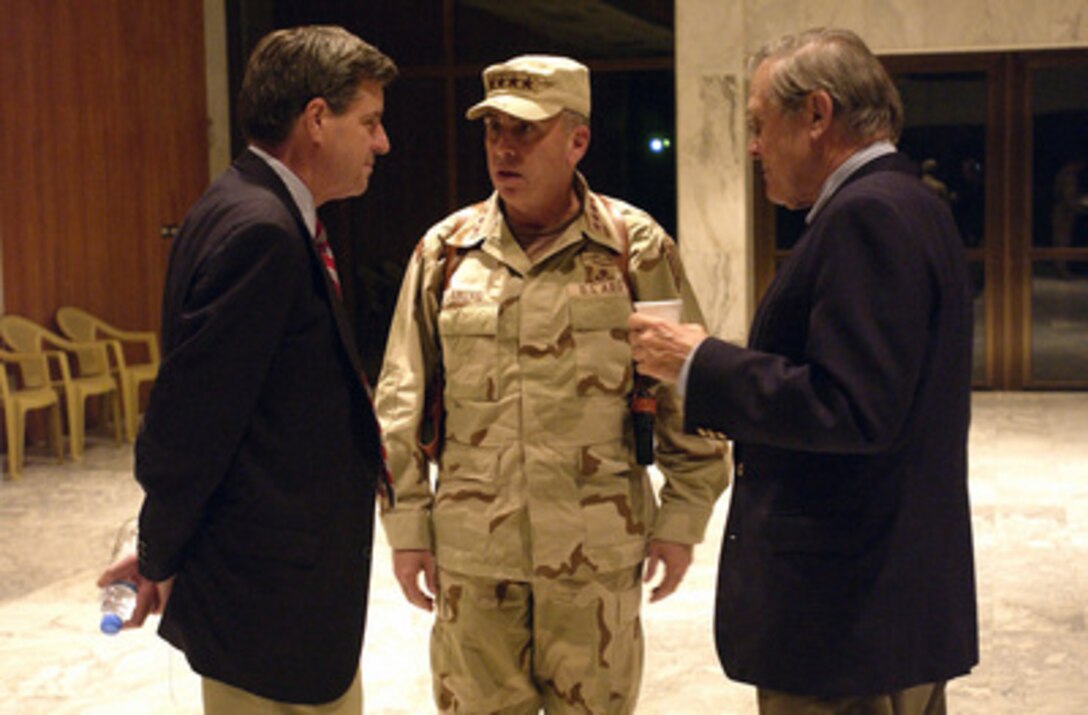 Commander U.S. Central Command Army Gen. John P. Abizaid (center) talks with Secretary of Defense Donald H. Rumsfeld (right) and Ambassador Paul Bremer (left) before Rumsfeld's departure from Baghdad International Airport, Baghdad, Iraq, on Dec. 6, 2003. Rumsfeld visited Iraq to meet with members of the Coalition Provisional Authority, senior military leaders and the troops deployed there. 