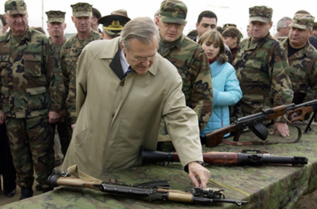 Secretary of Defense Donald H. Rumsfeld examines a weapon used by the Georgia Train & Equip Program at Kritsanisi, Georgia, on Dec. 5, 2003. Rumsfeld is in Georgia to meet with Acting President Nino Burjanadze, Minister of Defense Gen. David Tevzadze and to visit with U.S. troops deployed there. 