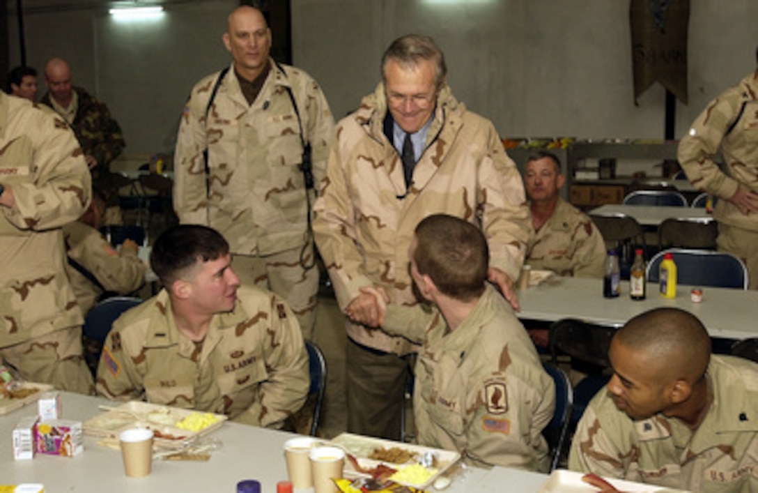 Secretary of Defense Donald H. Rumsfeld shakes hands with soldiers after having breakfast at Kirkuk Air Base, Kirkuk, Iraq, on Dec. 6, 2003. Rumsfeld is in Iraq to meet with members of the Coalition Provisional Authority, senior military leaders and the troops deployed there. 