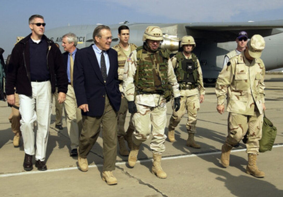 Secretary of Defense Donald H. Rumsfeld walks with Army Lt. Gen. Ricardo Sanchez after arriving at Baghdad International Airport in Iraq on Dec. 6, 2003. Rumsfeld is in Iraq to meet with members of the Coalition Provisional Authority, senior military leaders and the troops deployed there. 