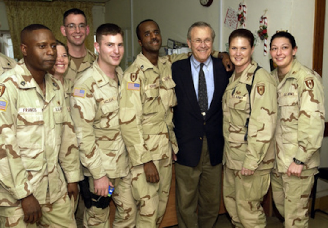 Secretary of Defense Donald H. Rumsfeld poses for photographs with soldiers from the 28th Combat Support Hospital in Baghdad, Iraq, on Dec. 6, 2003. Rumsfeld is in Iraq to meet with members of the Coalition Provisional Authority, senior military leaders and the troops deployed there. 