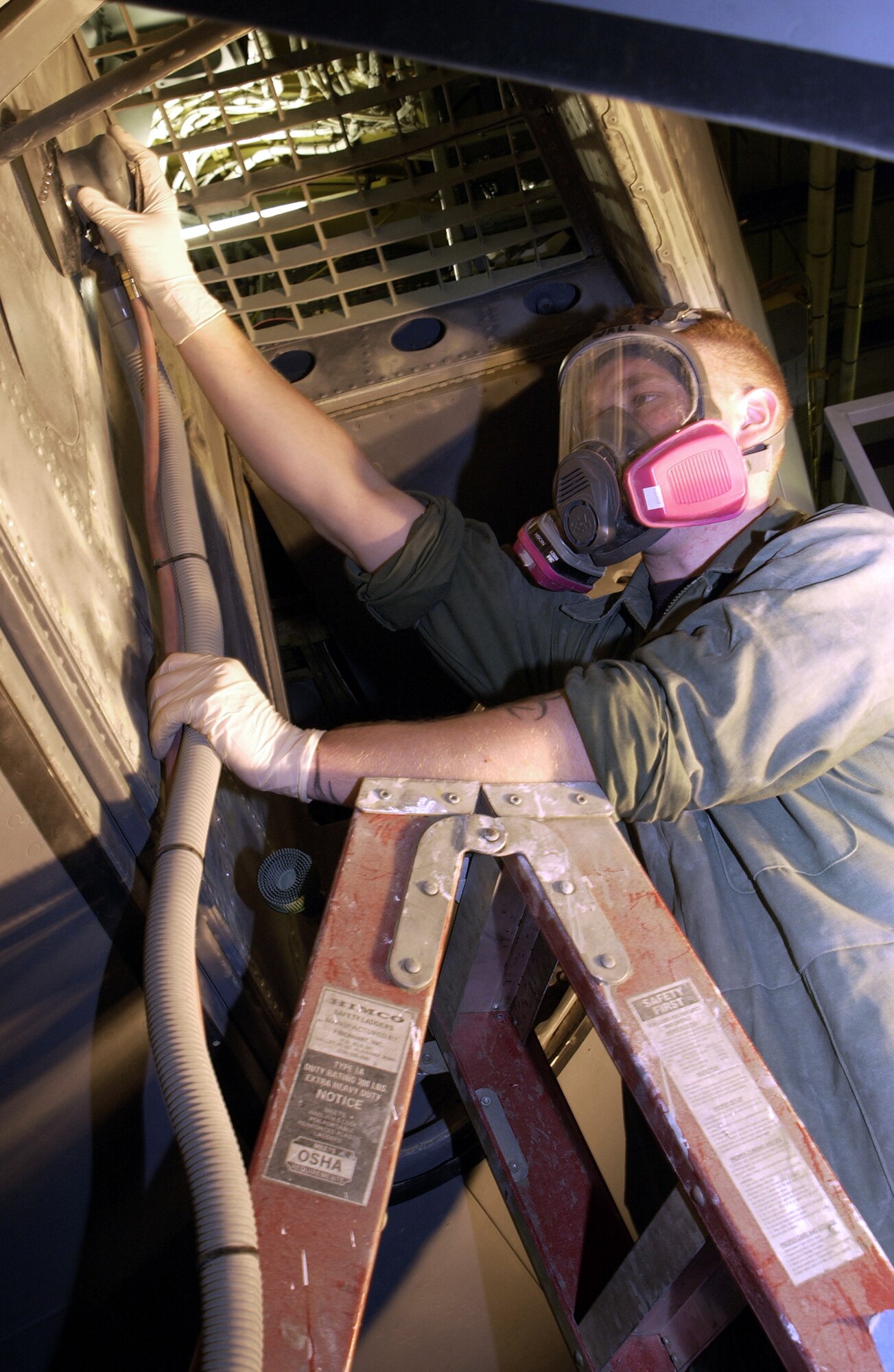 FAIRCHILD AIR FORCE BASE, Wash. -- Senior Airman Bryan Wall sands a crew entry chute before painting it. Wall is one of 14 airmen of the 92nd Maintenance Squadron's equipment excellence shop working to refurbish the interiors of aging KC-135 Stratotankers here.  (U.S. Air Force photo by Tech. Sgt. Martie Capoeman)