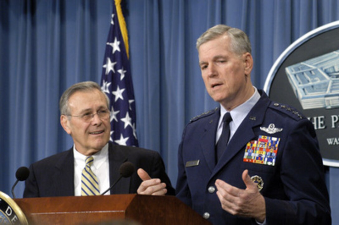 Secretary of Defense Donald H. Rumsfeld smiles as he listens to Chairman of the Joint Chiefs of Staff Gen. Richard B. Myers, U.S. Air Force, answer a difficult question during the Pentagon press briefing on Dec. 9, 2003. Rumsfeld and Myers updated reporters on the progress of the Iraqi security forces training and the coalitions' efforts in Iraq. 