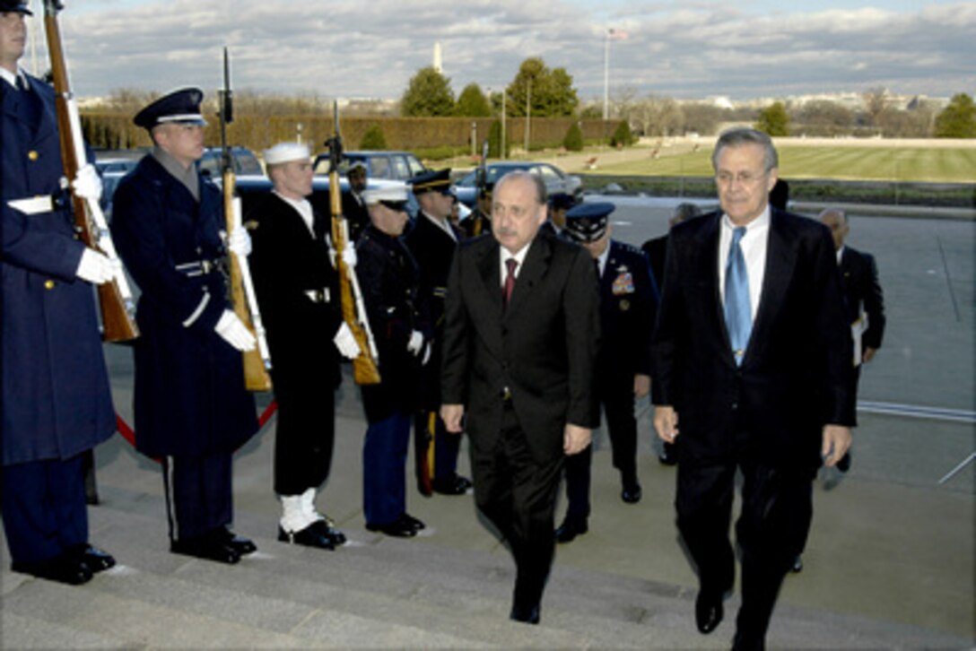 Secretary of Defense Donald H. Rumsfeld (right) escorts Argentine Minister of Defense Jose Pampuro (left) into the Pentagon on Dec. 11, 2003. The two defense leaders will meet to discuss a range of regional and global security issues of mutual interest. 