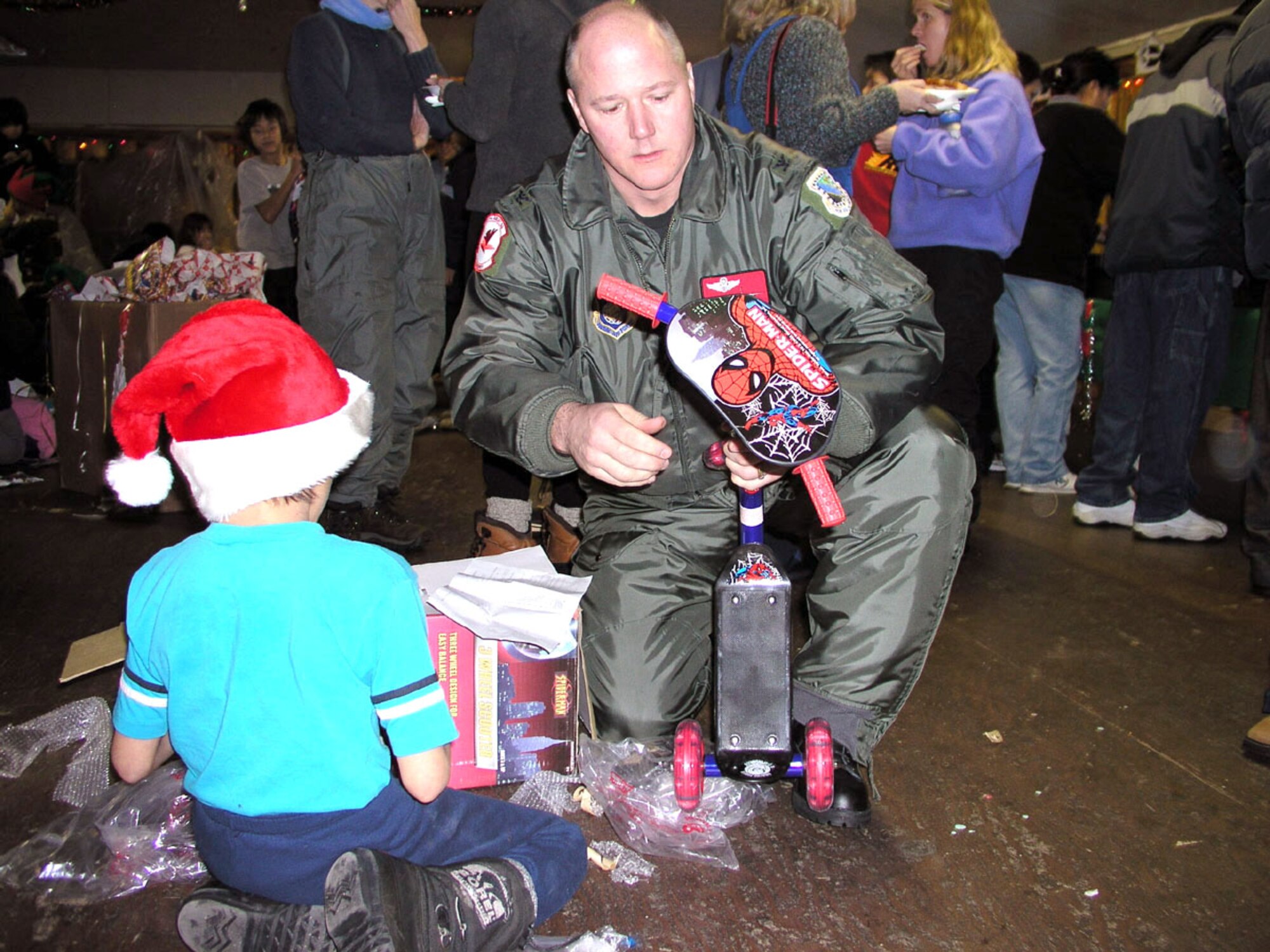 ARCTIC VILLAGE, Alaska -- Col. James Sturch helps a boy put together his new scooter.  Sturch participated in the 517th Airlift Squadron's annual visit here, 75 miles north of the Arctic Circle.  Sturch is the 3rd Wing vice commander at Elmendorf Air Force Base, Alaska.  (U.S. Air Force photo by Staff Sgt. Connie Bias)