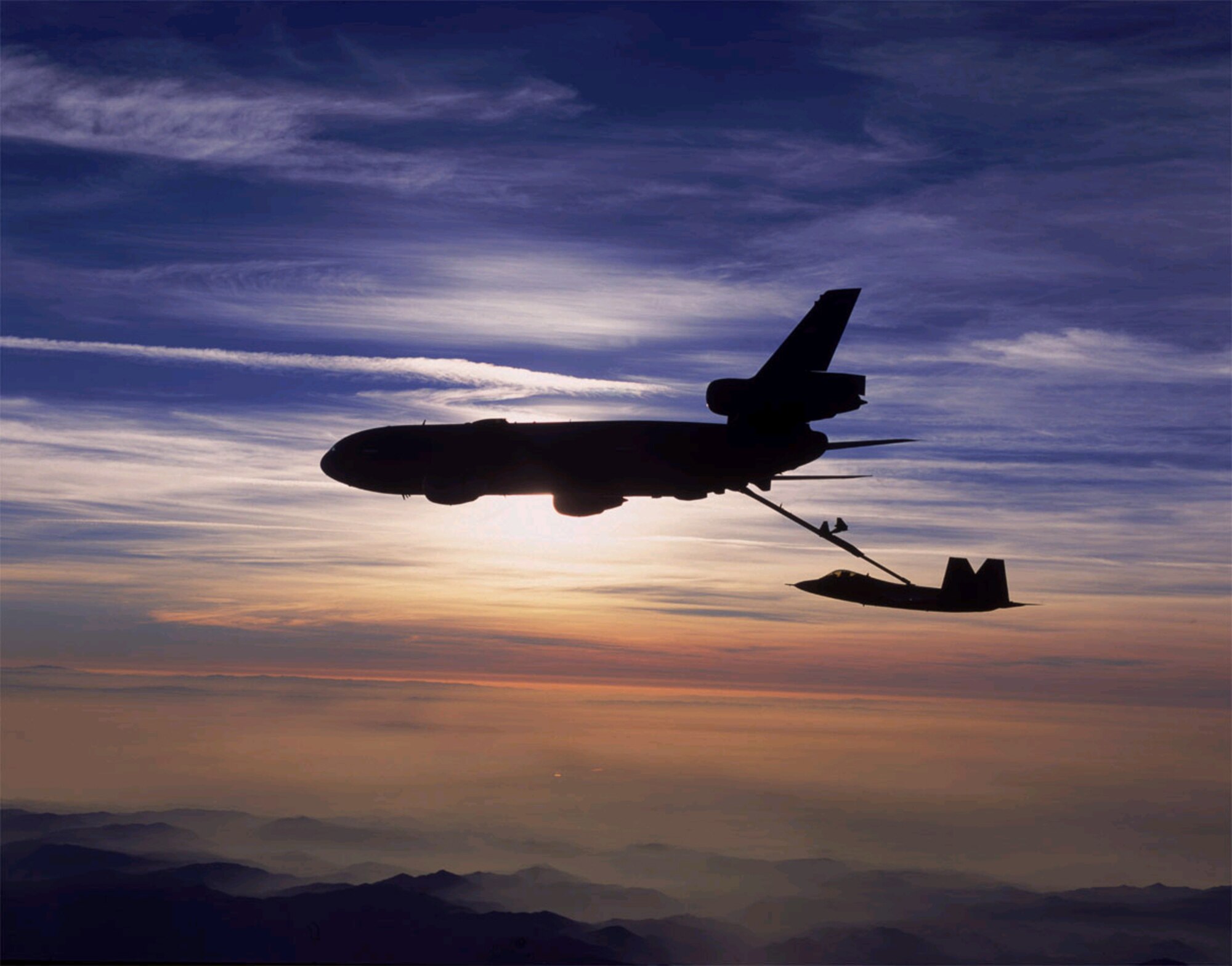 FILE PHOTO -- A KC-10 Extender from Travis Air Force Base, Calif., refuels an F/A-22 Raptor. The Raptor is the replacement for the F-15 Eagle. It is the most advanced fighter aircraft in the world, combining a revolutionary leap in technology and capability with reduced support requirements and maintenance costs. The F/A-22's integrated avionics gives it first-look, first-shot, first-kill capability that guarantees U.S. air dominance for decades. (U.S. Air Force photo by Judson Brohmer)