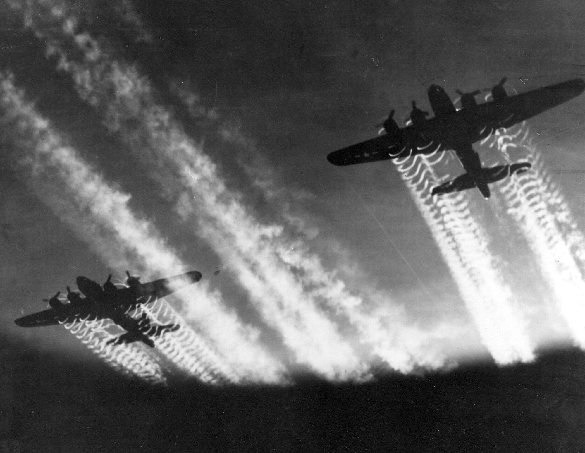 1940s -- The vapor trails from two Boeing B-17 Flying Fortress aircraft light up the night sky. The B-17 prototype first flew on July 28, 1935. (U.S. Air Force file photo)