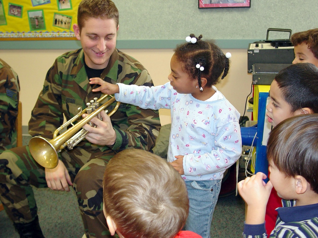 MINOT AIR FORCE BASE, N.D. -- Airman 1st Class Carl Eitzen shows Aniya Ingram how a trumpet works during a performance at the child development center here Dec. 19.  Eitzen was part of a brass quartet from Air Force Heartland Band of America at Offutt Air Force Base, Neb.  The musicians visited here Dec. 18 and 19 to perform holiday music for airmen and their families.  (U.S. Air Force photo by Tech. Sgt. Brian S. Orban)