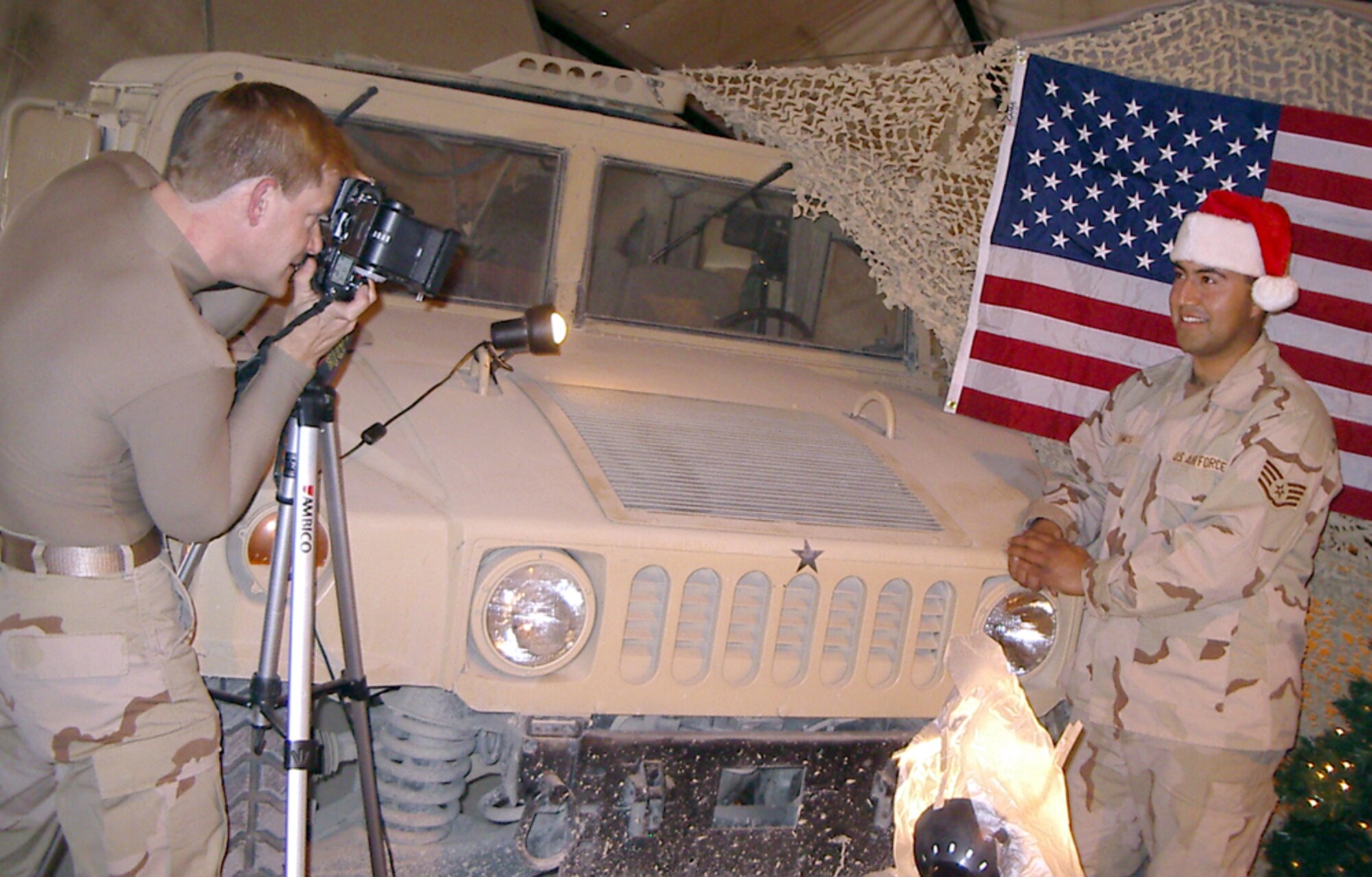 BAGRAM AIR BASE, Afghanistan -- Tech. Sgt. Brian Davidson (left) snaps a digital Christmas portrait of a fellow airman here.  Davidson spent nearly 16 hours capturing holiday photos of more than 250 airmen and soldiers.  He is the public affairs chief for the 455th Expeditionary Operations Group.  (Courtesy photo)