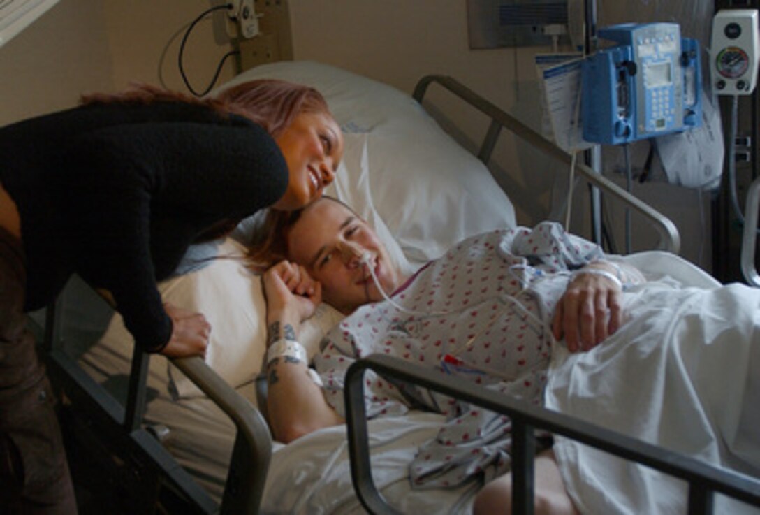 Tyra Banks poses for a photo as she visits with Army Spc. James Rednour, a patient at Walter Reed Army Medical Center, Washington, D.C., on Dec. 19, 2003. Banks, whose brother is Air Force 1st Lt. Devin Banks, a contracting officer stationed at Bolling Air Force Base, considers the military a "personal family thing" and wanted to lift injured service members' spirits. 