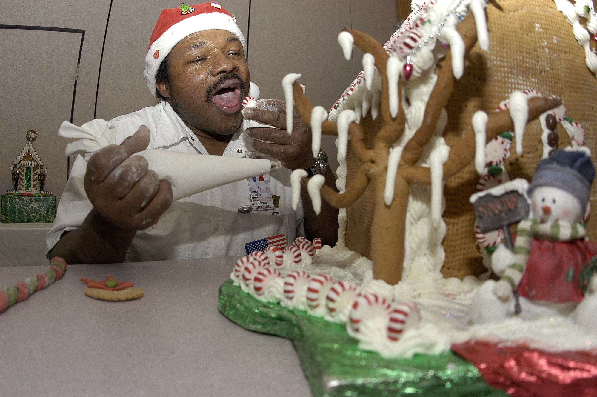 U.S. AIR FORCE ACADEMY, Colo. -- Chef Tommie Jones sometimes follows a "sample one, decorate two" pattern while hanging frosting icicles on his gingerbread masterpieces.  The lead baker and supervisor at Mitchell Hall here made 13 sweet structures to decorate the cadet and enlisted dining facilities.  (U.S. Air Force photo by Tech. Sgt. James A. Rush)