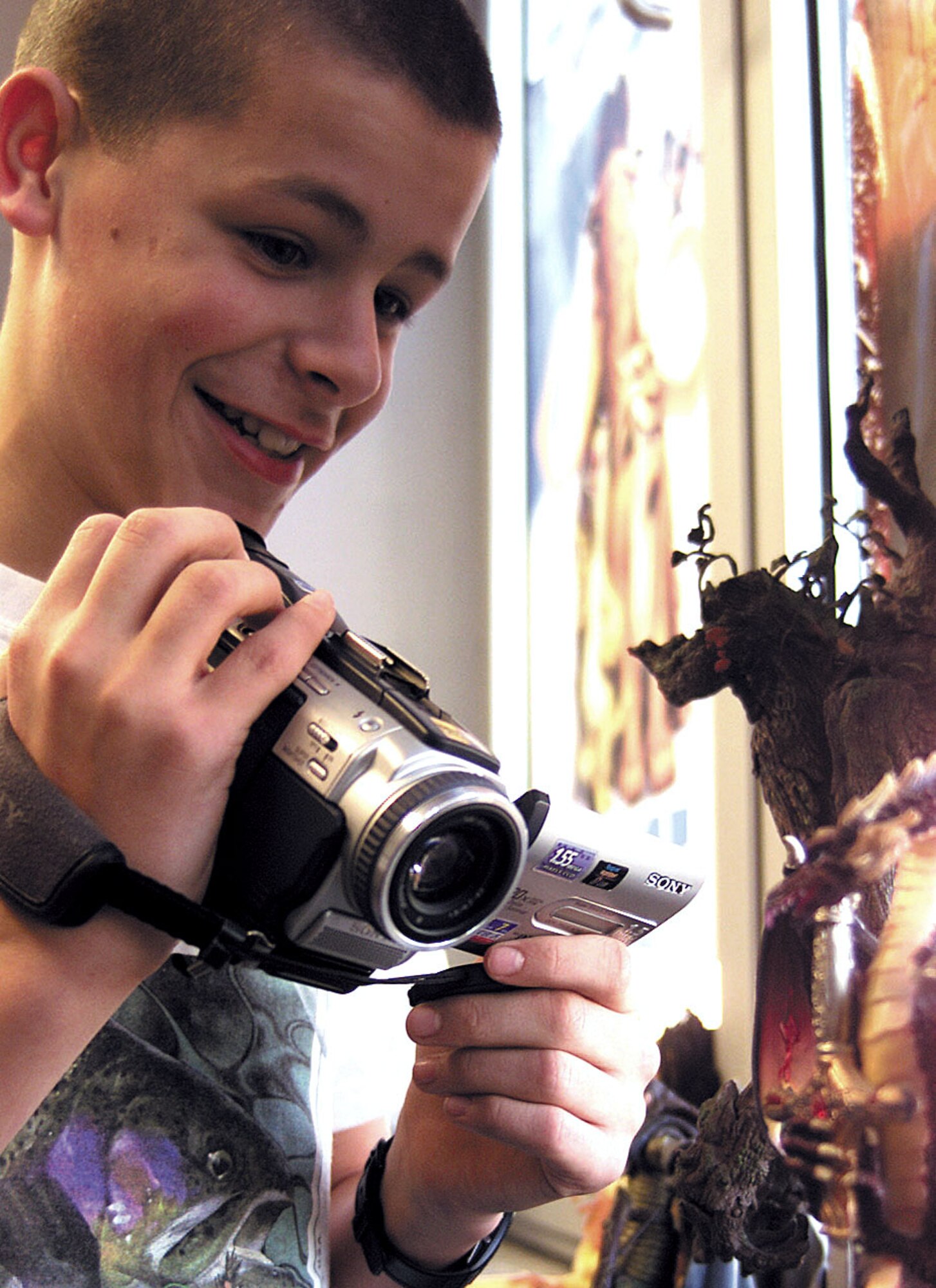 SPANGDAHLEM AIR BASE, Germany -- Steven Watts, a 13-year-old Spangdahlem Middle School student here, gets a tight shot of Pete Goetz's dragon.  Steven made a short film, "A Short Knight's Tale," for Goetz's class.  The short movie tells the story of a knight who "must be at least this tall" to participate in a jousting tournament.  Steven and a classmate spent more than three weeks planning, producing and designing "claymation" characters in the film.  (U.S. Air Force photo by Airman 1st Class Amaani Lyle)