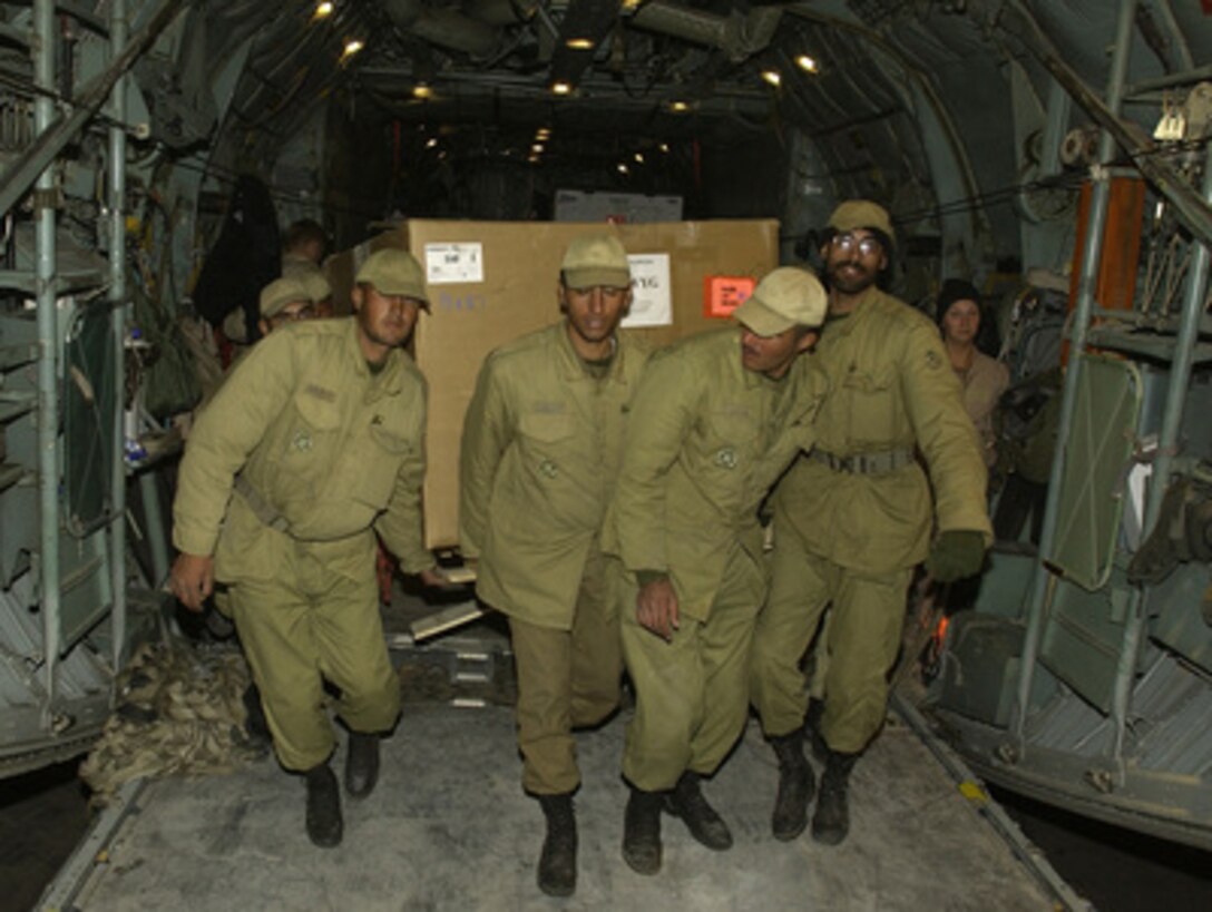 Iranian soldiers carry off a pallet from a U.S. Central Air Forces C-130 on the airfield at Kerman, Iran, on Dec. 28, 2003. The C-130 crew flew in five pallets containing 20 thousand pounds of medical supplies from logistical bases within the region into Kerman two days after a devastating earthquake destroyed the city of Bam, Iran. 