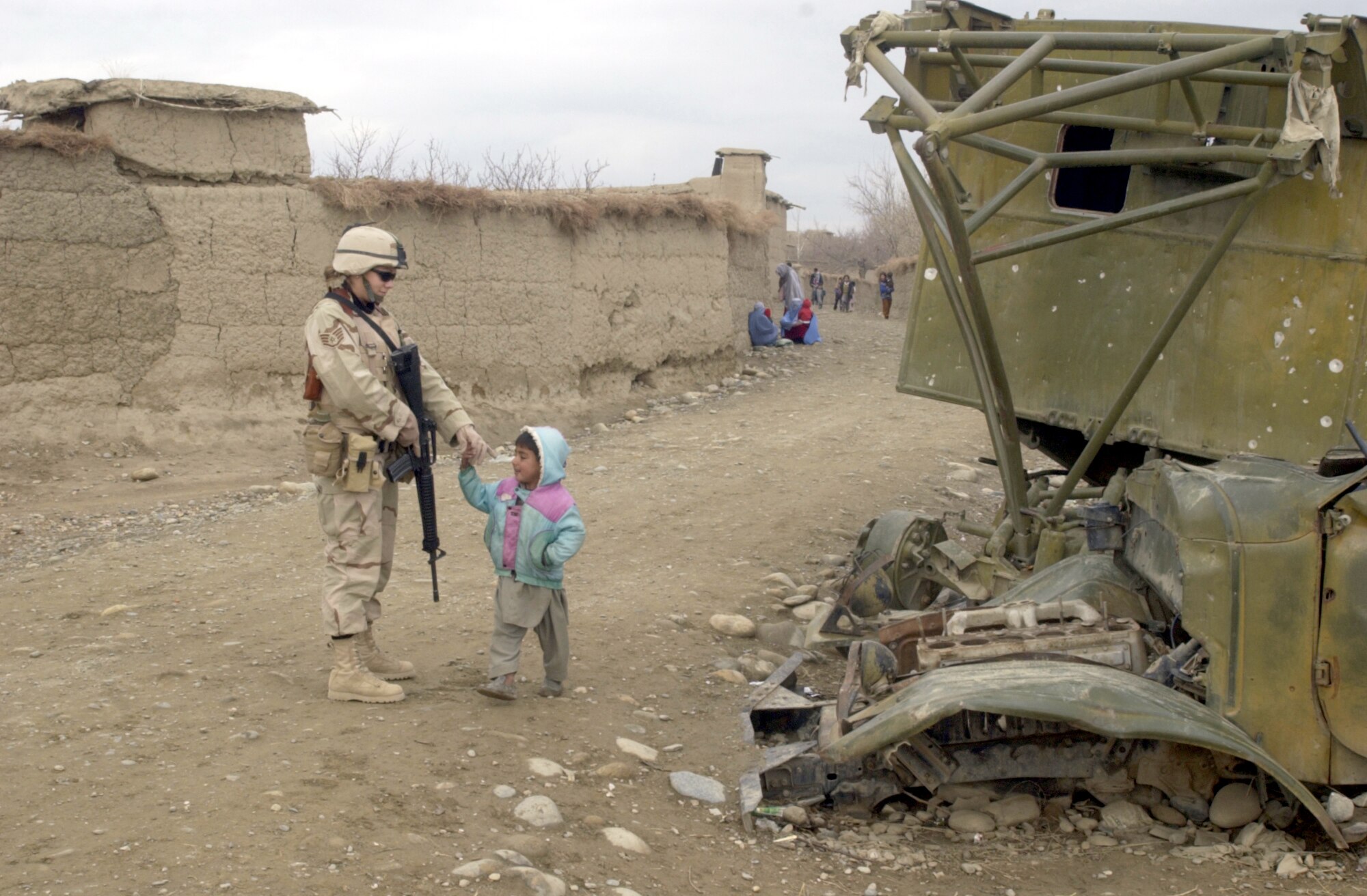 JANGADAM VILLAGE, Afghanistan -- Staff Sgt. Crystal Whittaker visits with an Afghan child here while providing perimeter security during the 455th Expeditionary Operations Group's delivery of humanitarian supplies Dec. 31.  Whittaker is a security specialist with the 455th Expeditionary Operations Group.  (U.S. Air Force photo by Tech. Sgt. Brian Davidson)