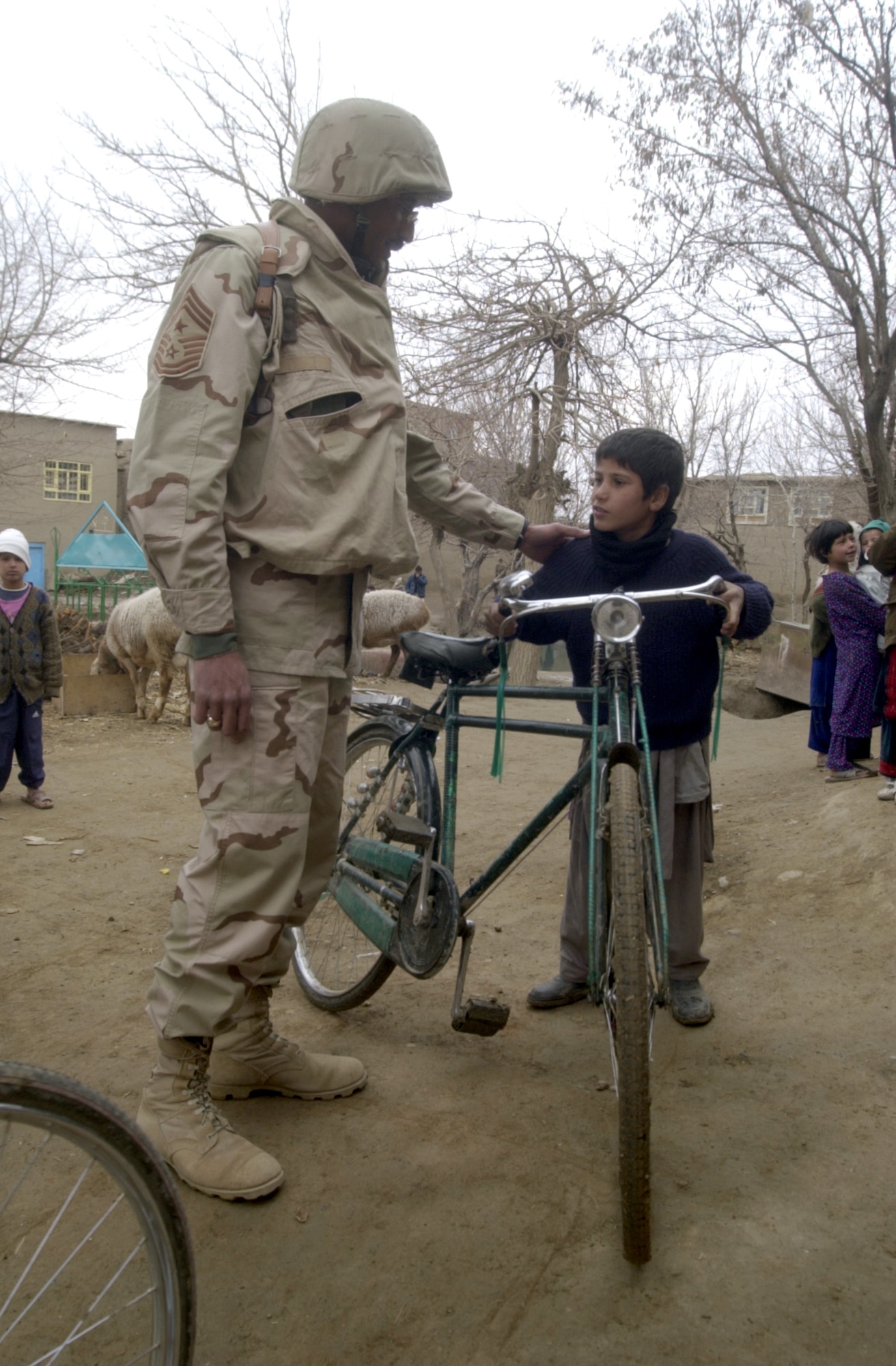 JANGADAM VILLAGE, Afghanistan -- Chief Master Sgt. Timothy Sydnor visits with a child here during the 455th Expeditionary Operations Group's delivery of humanitarian supplies Dec. 31.  Sydnor is the 455th Air Expeditionary Wing command chief.  (U.S. Air Force photo by Tech. Sgt. Brian Davidson)