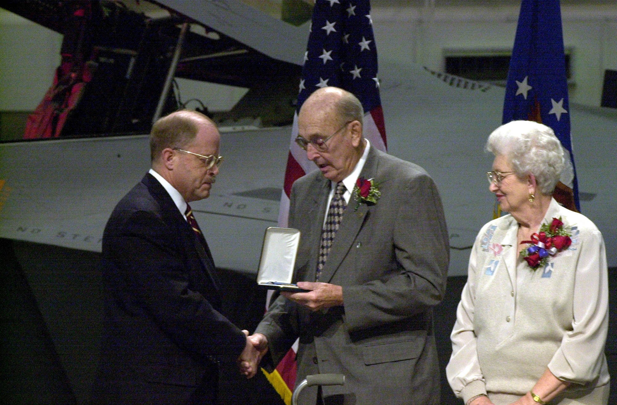 WRIGHT-PATTERSON AIR FORCE BASE, Ohio -- Alice Pitsenbarger (right) observes as her husband, William F. Pitsenbarger (center), accepts the Medal of Honor on his son's behalf from Secretary of the Air Force Whit Peters during a ceremony Dec. 8, here. (U.S Air Force photo by Tech. Sgt. Gary Coppage)
