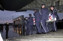 RAMSTEIN AIR BASE, Germany -- Honors are rendered as the remains of five sailors killed in an apparent attack on the USS Cole are escorted from a C-17 Globemaster III here Oct. 13, 2001. The Navy destroyer was in the port of Aden, Yemen, when the incident occurred. (U.S. Air Force photo by Master Sgt. Keith Reed)

