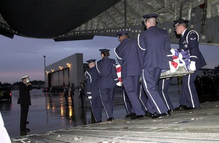 RAMSTEIN AIR BASE, Germany -- Honors are rendered as the remains of five sailors killed in an apparent attack on the USS Cole are escorted from a C-17 Globemaster III here Oct. 13, 2001. The Navy destroyer was in the port of Aden, Yemen, when the incident occurred. (U.S. Air Force photo by Master Sgt. Keith Reed)

