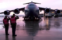 AMSTEIN AIR BASE, Germany -- Two flightline personnel at Ramstein Air Base, Germany, pay their last respects to the five sailors killed in an apparent attack on the USS Cole as they are escorted from the C-17 Globemaster III that arrived from Yemen. The Navy destroyer was in the port of Aden, Yemen, when the incident occurred. (U.S. Air Force photo by Master Sgt. Keith Reed)
