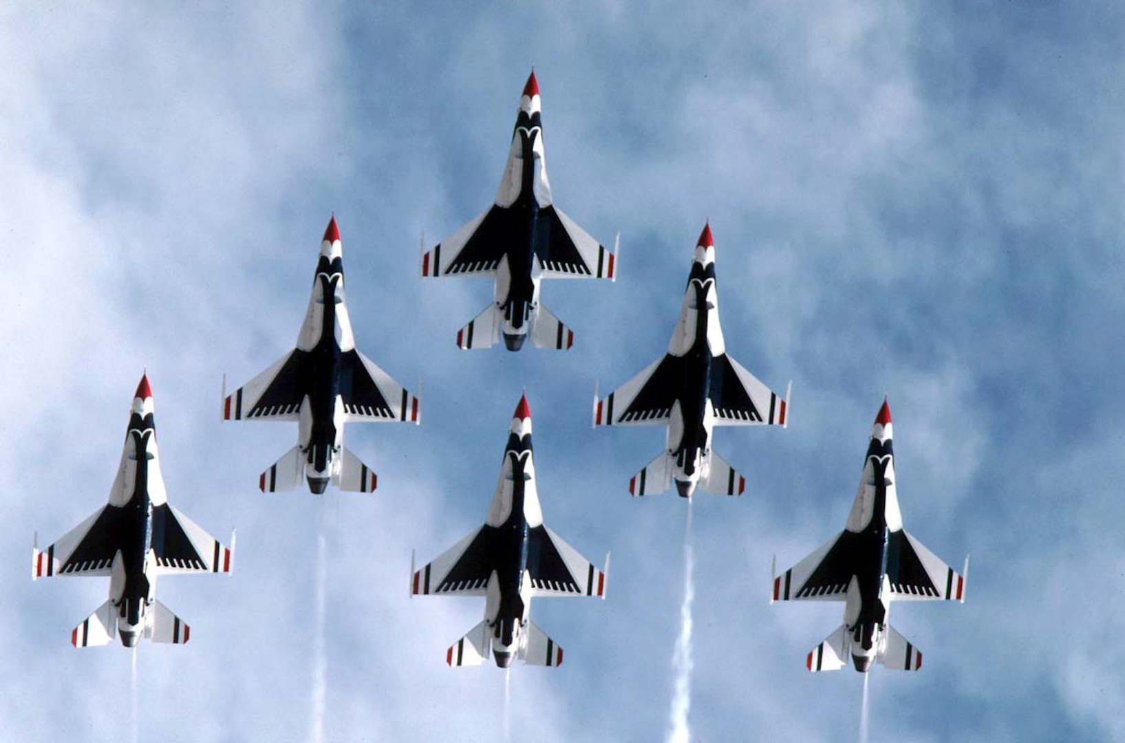 FILE PHOTO -- The U.S. Air Force Air Demonstration Squadron, the Thunderbirds, performs precision aerial maneuvers demonstrating the capabilities of Air Force high performance aircraft to people throughout the world. The squadron exhibits the professional qualities the Air Force develops in the people who fly, maintain and support these aircraft. The Thunderbirds squadron is an Air Combat Command unit composed of eight pilots (including six demonstration pilots), four support officers, three civilians and more than 130 enlisted personnel performing in 25 career fields. The Lockheed Martin (formerly General Dynamics) F-16 Fighting Falcon represents the full range of capabilities possessed by the Air Force's tactical fighters. This highly maneuverable multi-role fighter has proven itself to be one of the world's best precision tactical bombers and air-to-air combat aircraft. The only modifications needed to prepare the aircraft for its air demonstration role are installing a smoke-generating system in the space normally reserved for the 20mm cannon, and the painting of the aircraft in Thunderbird colors. (U.S. Air Force photo)
