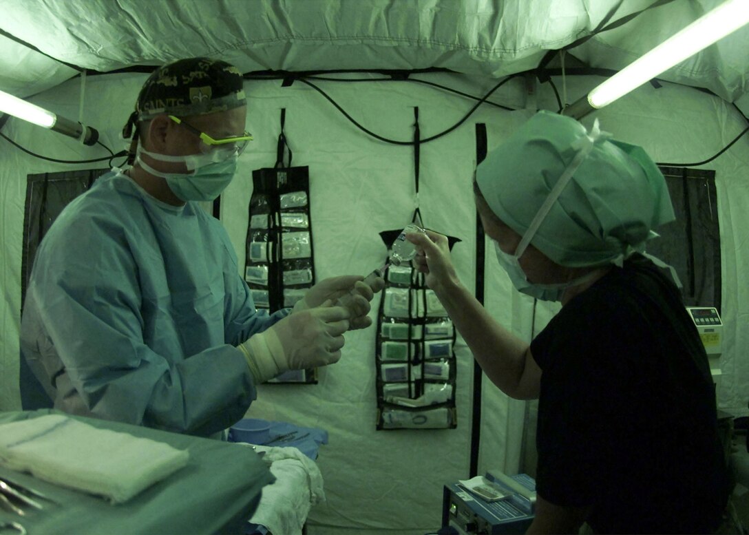 OPERATION ENDURING FREEDOM -– Capt. Cynthia Warwick (right) and Staff Sgt. Chad Smith, both from the  81st Medical Surgical Squadron at Keesler Air Force Base, Miss., prepare a syringe with local anesthesia. Warwick, a nurse, and Smith, a surgical technician, deployed with the 28th Medical Group are preparing to assist in a Keloid excision in support of Operation Enduring Freedom. (U.S. Air Force photo by Senior Airman Rebeca M. Luquin) 